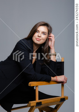 Businesswoman relaxing on director chair, touching her hair Businesswoman relaxing on director chair, touching her hair 143274350