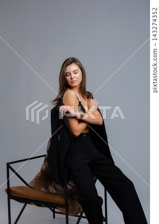 Businesswoman removing jacket sitting on chair with closed eyes Businesswoman removing jacket sitting on chair with closed eyes 143274352