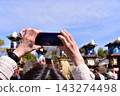 Inuyama City, Aichi Prefecture, Japan: Springtime Inuyama Festival and cherry blossoms in full bloom; floats gathered in front of Inuyama Castle Square; tourists taking photos with their smartphones. 143274498