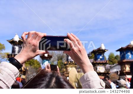 Inuyama City, Aichi Prefecture, Japan: Springtime Inuyama Festival and cherry blossoms in full bloom; floats gathered in front of Inuyama Castle Square; tourists taking photos with their smartphones. Inuyama City, Aichi Prefecture, Japan: Springtime Inuyama Festival and cherry blossoms in full bloom; floats gathered in front of Inuyama Castle Square; tourists taking photos with their smartphones. 143274498