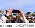 Inuyama City, Aichi Prefecture, Japan: Springtime Inuyama Festival and cherry blossoms in full bloom; floats gathered in front of Inuyama Castle Square; tourists taking photos with their smartphones. 143274499