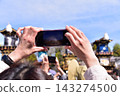 Inuyama City, Aichi Prefecture, Japan: Springtime Inuyama Festival and cherry blossoms in full bloom; floats gathered in front of Inuyama Castle Square; tourists taking photos with their smartphones. 143274500