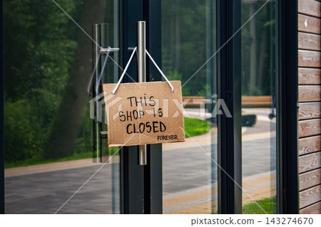 Sign SHOP CLOSED on welcome door of small shop. Local business closure. Owners facing economic struggles and client loss Sign SHOP CLOSED on welcome door of small shop. Local business closure. Owners facing economic struggles and client loss 143274670