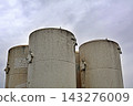 Weathered Storage Vat Tops Against A Grey Overcast Weathered Storage Vat Tops Against A Grey Overcast 143276009