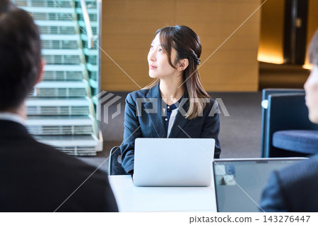 一位年輕的女員工在辦公室打開筆記型電腦,認真地聽著講解。 一位年輕的女員工在辦公室打開筆記型電腦,認真地聽著講解。 143276447