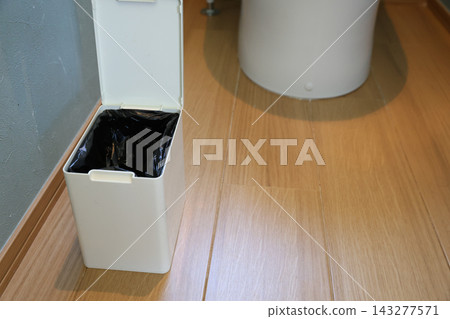 家用廁所裡放置了一個衛生盒和一個黑色塑膠袋。 家用廁所裡放置了一個衛生盒和一個黑色塑膠袋。 143277571