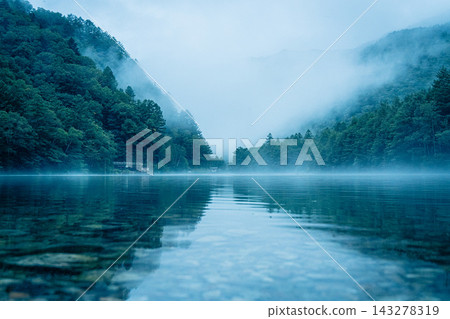 The fantastical scenery of Taisho Pond in Kamikochi, shrouded in morning mist. The fantastical scenery of Taisho Pond in Kamikochi, shrouded in morning mist. 143278319
