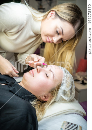 Eyelash extension procedure in beauty salon. Lashes close up. Concept spa lash.  143278570