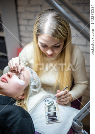 Eyelash extension procedure in beauty salon. Lashes close up. Concept spa lash.  143278584