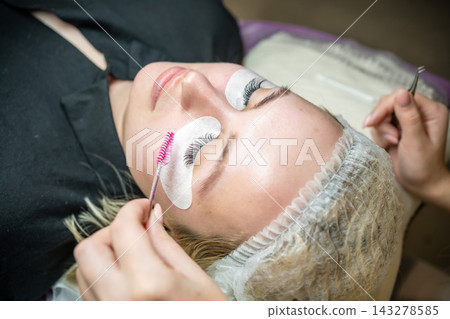 Eyelash extension procedure in beauty salon. Lashes close up. Concept spa lash. Eyelash extension procedure in beauty salon. Lashes close up. Concept spa lash. 143278585