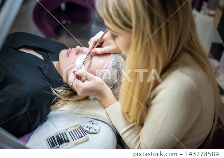 Eyelash extension procedure in beauty salon. Lashes close up. Concept spa lash.  143278589