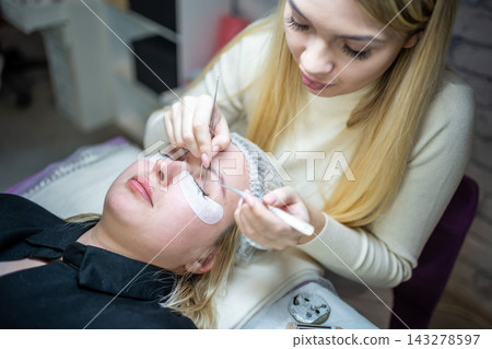 Eyelash extension procedure in beauty salon. Lashes close up. Concept spa lash.  143278597