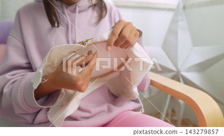 Young woman arranging embroidered hoop art for display Young woman arranging embroidered hoop art for display 143279857