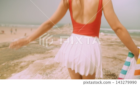 Energetic woman in swimsuit spinning near sunlit stones Energetic woman in swimsuit spinning near sunlit stones 143279990