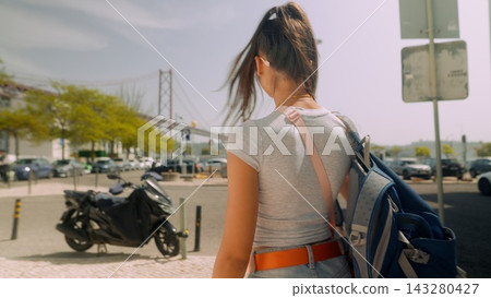 Young woman student commuting with backpack at intersection Young woman student commuting with backpack at intersection 143280427