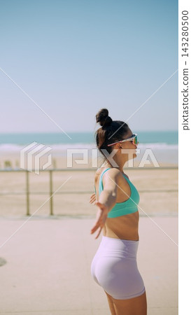 Female runner performing chest opener stretch before run 143280500