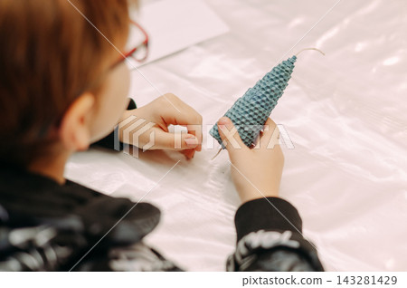 Child holding handmade beeswax candle during candle making workshop Child holding handmade beeswax candle during candle making workshop 143281429