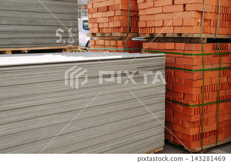 Stacks of bricks and roofing sheets prepared for residential building renovation 143281469