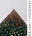 Christmas Tree with Colorful Ornaments and Lights Viewed from Below Against Overcast Sky 143283433