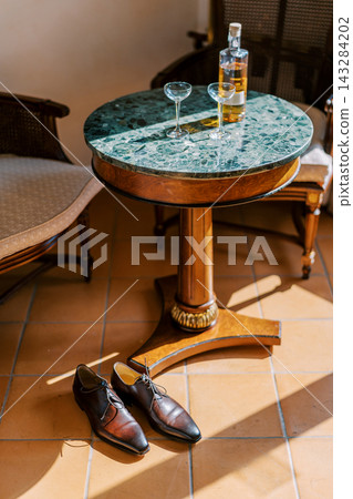 Elegant marble table with whiskey and dress shoes Elegant marble table with whiskey and dress shoes 143284202