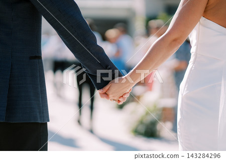 Close Up of Bride and Groom Holding Hands at Wedding Ceremony Close Up of Bride and Groom Holding Hands at Wedding Ceremony 143284296