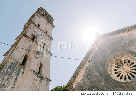 Historic stone church with clock tower and rose window Historic stone church with clock tower and rose window 143284385