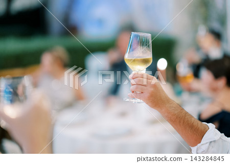 Lively party scene captured with hands raising glasses and joyful expressions highlighting merriment Lively party scene captured with hands raising glasses and joyful expressions highlighting merriment 143284845