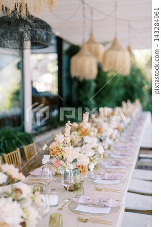 Elegant Outdoor Event Table Setting with Floral Arrangements Elegant Outdoor Event Table Setting with Floral Arrangements 143284961