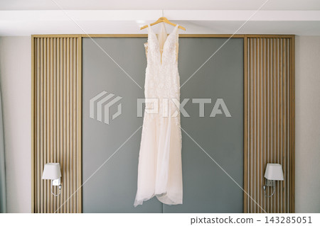 Elegant bridal attire. Soft natural light highlights beautiful ivory bridal gown indoors Elegant bridal attire. Soft natural light highlights beautiful ivory bridal gown indoors 143285051