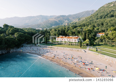 Beach paradise scene. Serene shoreline with bright water and cheerful visitors enjoying summer Beach paradise scene. Serene shoreline with bright water and cheerful visitors enjoying summer 143285098