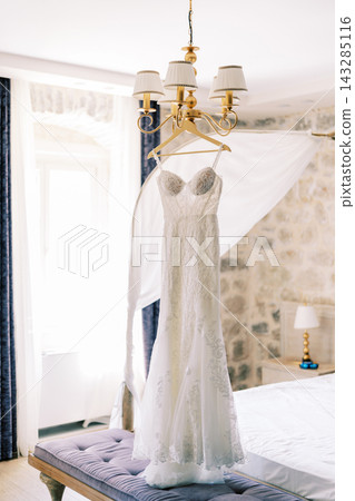Serene bridal preparation environment featuring delicate dress and romantic lighting ambiance Serene bridal preparation environment featuring delicate dress and romantic lighting ambiance 143285116