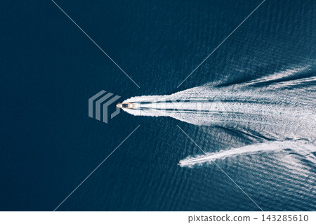 Speedy vessel slicing peaceful waters. Speedboat swiftly carving through tranquil sea surface Speedy vessel slicing peaceful waters. Speedboat swiftly carving through tranquil sea surface 143285610