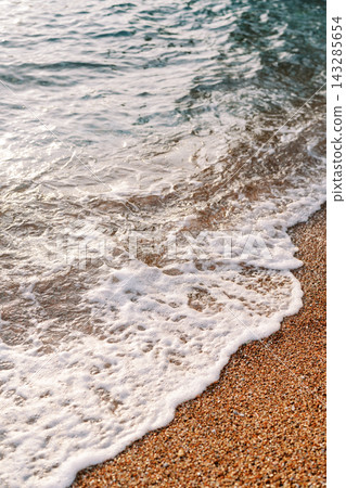 Calm Shoreline With Shimmering Stones. Peaceful Beach With Sparkling Rocks And Gentle Waves Calm Shoreline With Shimmering Stones. Peaceful Beach With Sparkling Rocks And Gentle Waves 143285654