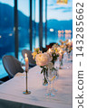 Romantic Waterfront Dining. Charming Dinner Arrangement With Floral Decor And Warm Lighting 143285662