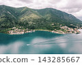 Serene Coastal Scene. Peaceful Seaside Village With Reflective Water And Surrounding Greenery 143285667