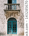 Timeworn Masonry Facade Featuring Teal Entrance And Ornate Carved Balustrade Balcony 143285670