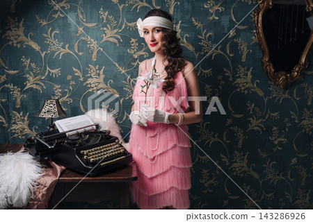 Elegant woman in 1920s style with magnolia flower and vintage typewriter Elegant woman in 1920s style with magnolia flower and vintage typewriter 143286926