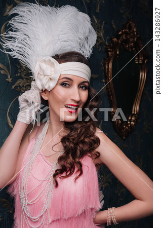 Joyful young woman and girl in 1920s flapper style with large white feather Joyful young woman and girl in 1920s flapper style with large white feather 143286927