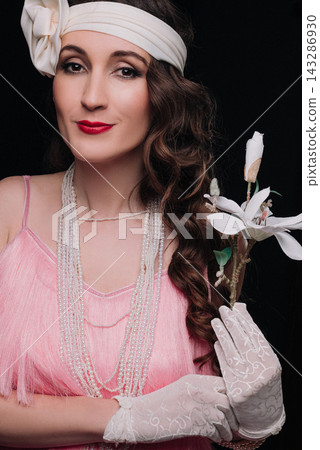 Elegant young woman and girl in 1920s style holding a white magnolia flower Elegant young woman and girl in 1920s style holding a white magnolia flower 143286930