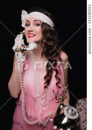 Elegant young woman and girl talking on a vintage rotary telephone 143286931