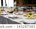 Gourmet appetizers and wine glasses on a banquet table 143287383