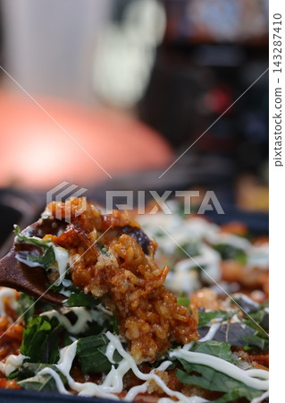 Close-Up of Savory Rice Dish with Greens and Sauce Close-Up of Savory Rice Dish with Greens and Sauce 143287410