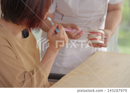 護理人員使用牙科模型指導口腔護理。 護理人員使用牙科模型指導口腔護理。 143287979