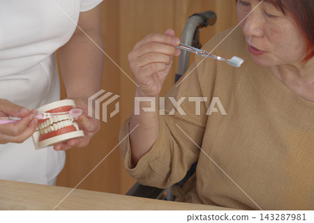 護理人員使用牙科模型指導口腔護理。 143287981