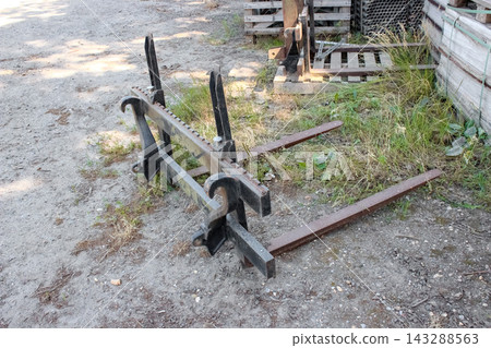 Forklift pallet attachment for loaders, featuring heavy-duty steel forks, a notched adjustable carriage frame, and quick-attach mounting hooks. Forklift pallet attachment for loaders, featuring heavy-duty steel forks, a notched adjustable carriage frame, and quick-attach mounting hooks. 143288563