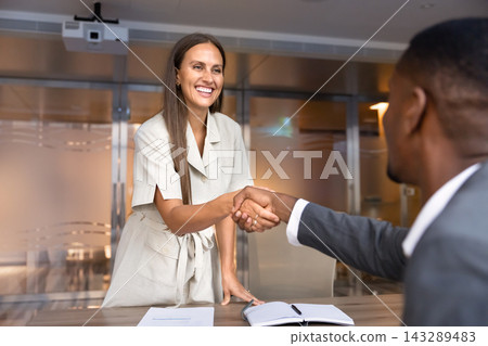 Smiling female applicant shaking hands with HR managers Smiling female applicant shaking hands with HR managers 143289483