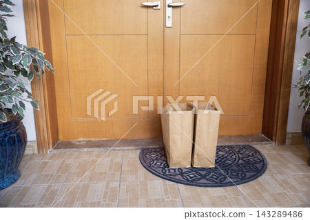 Two big paper bags with food brought to house entrance Two big paper bags with food brought to house entrance 143289486