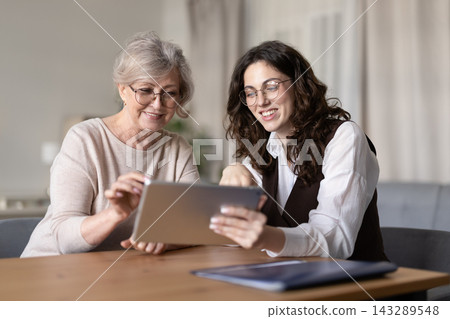 Advisor showing information on digital tablet to senior woman client Advisor showing information on digital tablet to senior woman client 143289548