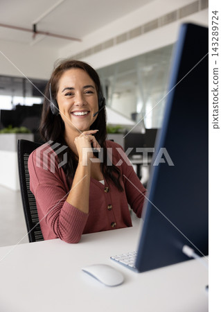Portrait of smiling woman, callcenter employee posing seated at desk Portrait of smiling woman, callcenter employee posing seated at desk 143289724