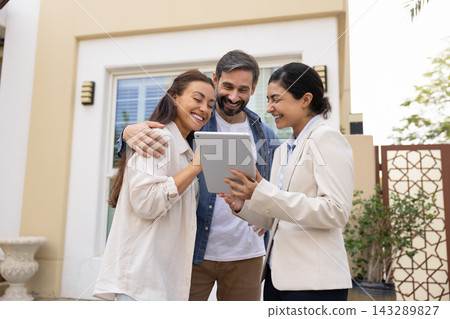 Smiling realtor with tablet show customers property information on screen 143289827